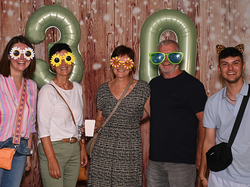 Drei Kollegen gemeinsam in einer Fotobox beim Firmensommerfest